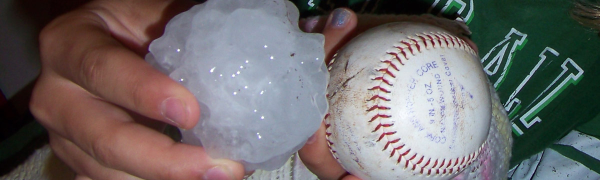 photo of hail being held next to a baseball