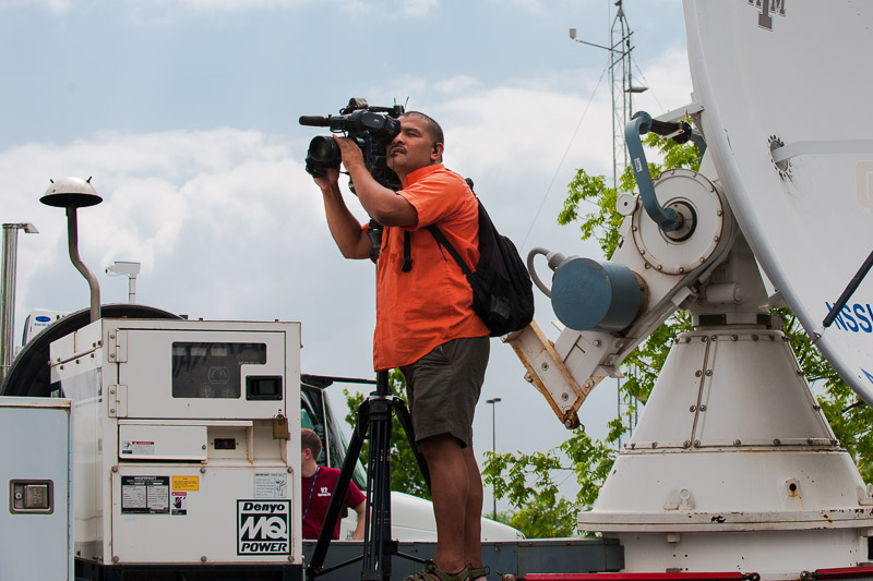 Media cameraman shooting from atop a mobile radar vehicle