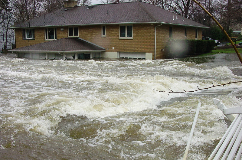 flash flood waters rushing past house